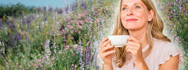 Femme sereine savourant une tisane dans un jardin fleuri, évoquant les plantes anti-stress — SANUSq Health