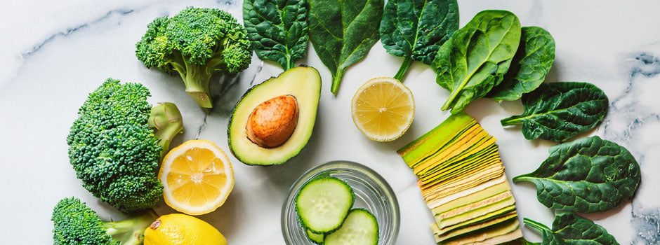 Légumes verts, avocat et citron sur un plan en marbre, évoquant le régime alcalin — SANUSq Health