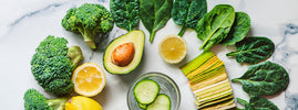 Légumes verts, avocat et citron sur un plan en marbre, évoquant le régime alcalin — SANUSq Health