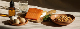 Aliments riches en vitamine D3 et K2 (natto, gouda, jaune d'œuf, saumon) sous une lumière d'automne